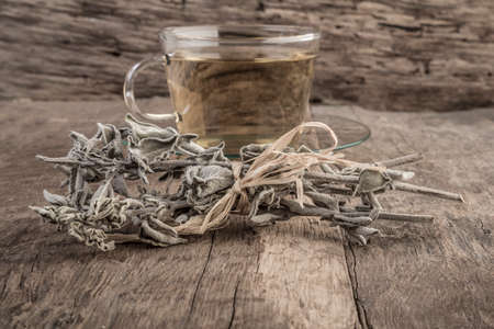 A cup of natural sage tea on wooden tableの写真素材
