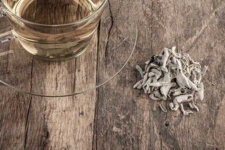 A cup of natural sage tea on wooden tableの写真素材