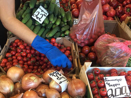 Hand picking tomatoes in a grocery store in Kiev, Ukraineの写真素材