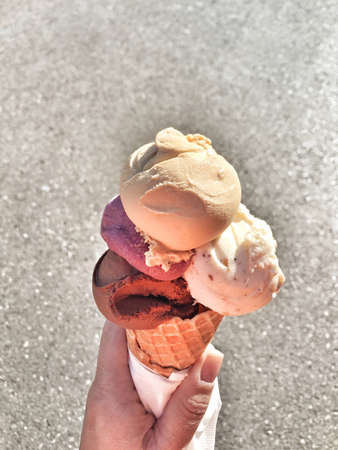a female hand holding ice cream in a street