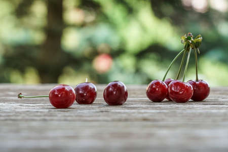 Some ripe cherry fruits on wooden tableの写真素材