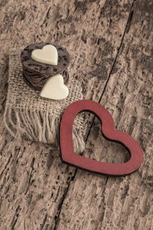 heart shaped chocolate bars and red heart on wooden tableの写真素材