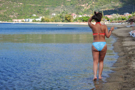 A woman walking on a sandy beach in summerの写真素材