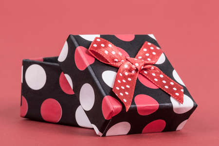 an opened small gift box on red background with copy space