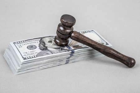 Wooden gavel on American Dollars on greyの写真素材