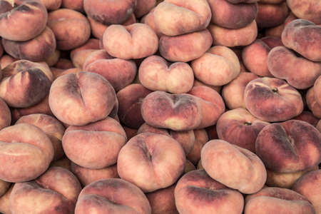 pile of flat peaches as a background