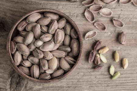 Some pistachios on a wooden table