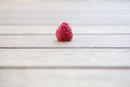 A ripe raspberry on wooden table with copy spaceの写真素材