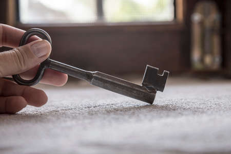A female hand holding an old rustic key