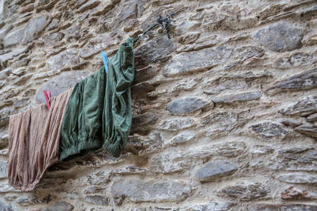 Some clothes hanged on a wallの写真素材