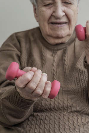 A healthy senior woman lifting dumbbells