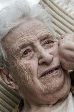 Closeup portrait of thoughtful senior woman at homeの写真素材