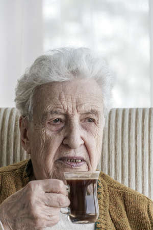 Closeup of a senior woman drinking coffee at home