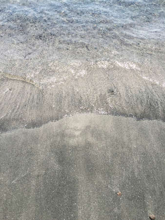 Soft wave of sea on a sandy beach in summer with copy space