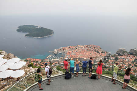 Tourists at a vantage point at Mount Srdj looking at the Old Town of Dubrovnik from above in Croatia.のeditorial素材