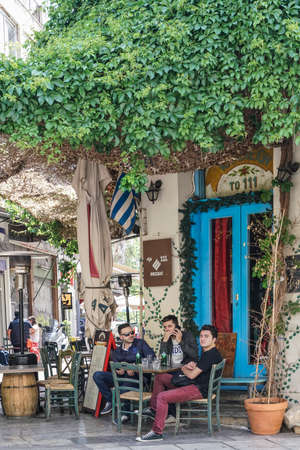 Cozy street cafe at Athens downtown with stylish furniture and decorations, people are drinking and talking outside in Athens, Greeceのeditorial素材