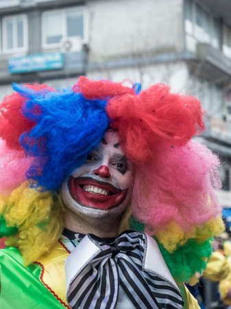 Man in colorful clown costume during the annual Carnival Parade in Xanthi, Greece. Group of people dancing dressed in carnival costumes during the festival at streets of Xanthi in Greece.のeditorial素材