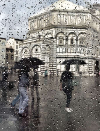 People walking under rain in Duomo Di Firenze in Florence, Italy.のeditorial素材