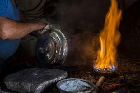 Closeup hand of a traditional Turkish tinsmith / copper smith workingの写真素材