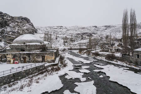 An old Ottoman bath by frosted river in Kars city in Turkey.