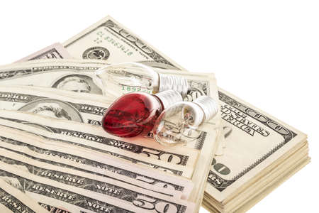 Some lightbulbs on pile of American Dollars isolated on whiteの写真素材