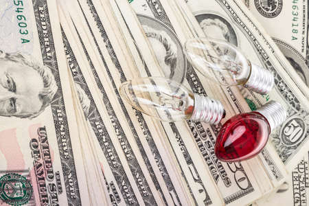 Some lightbulbs on background with pile of American Dollarsの写真素材