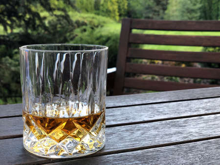 closeup glass of whiskey on table at garden