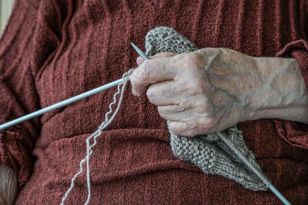 close up hand of a senior woman knittingの写真素材