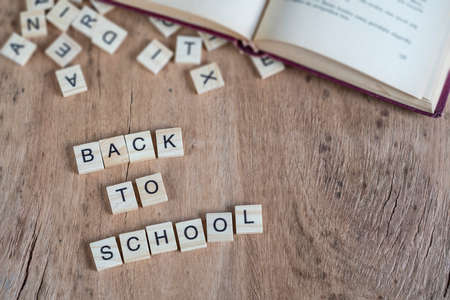 back to school template with cube letters and book on wooden tableの写真素材