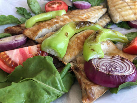 grilled sea bass served with sliced vegetables and salad