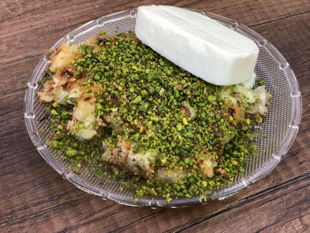 Kunefe that is traditional Turkish dessert with cheese inside served with pistachio
