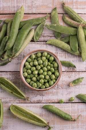 fresh whole peas and seeds on a wooden tableの写真素材