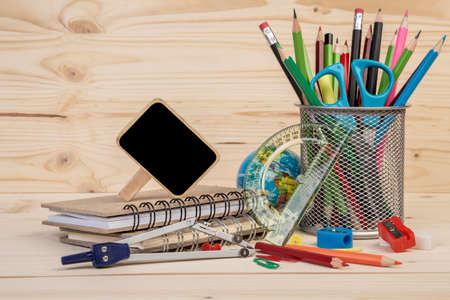 back to school template with stationeries and books on a wooden tableの写真素材