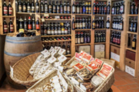 blurred background with variety of wine bottles on shelves in a store