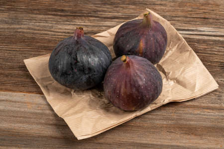 ripe purple figs on a wooden tableの写真素材