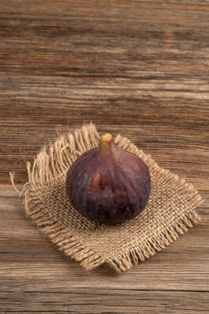 A ripe purple fig on a wooden tableの写真素材