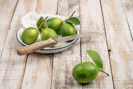 fresh green limes on a wooden table with copy spaceの写真素材
