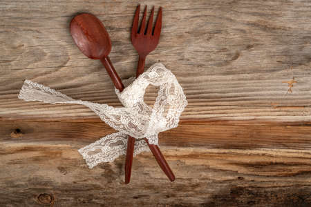 carved spoon and fork on a wooden background with copy spaceの写真素材
