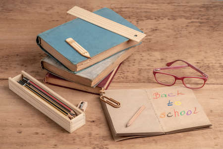 back to school template with books and pencils on a wooden table