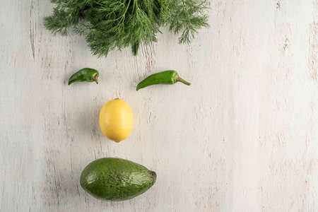 face shape made with fresh vegetables on a wooden table with copy space