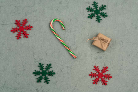 gift box and candy cane on a green background for new year with copy space