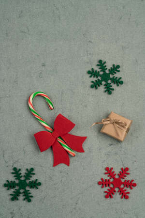 gift box and candy cane on a green background for new year with copy space
