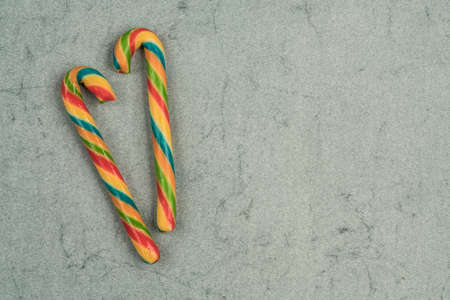 stick candy canes on a green background for new year