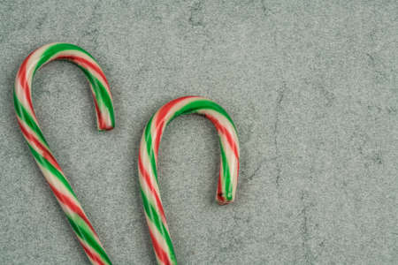 stick candy canes on a green background for new yearの写真素材