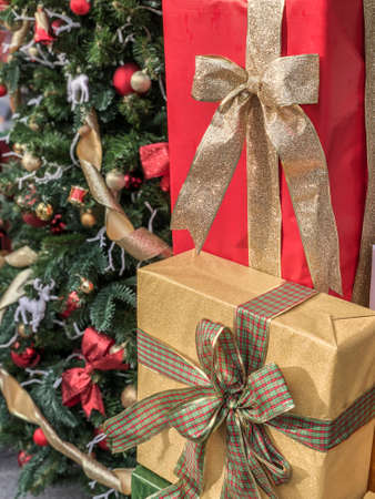 gift boxes next to a noel tree decorated for new year