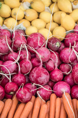 pile of fresh radish and lemons in a grocery storeの写真素材