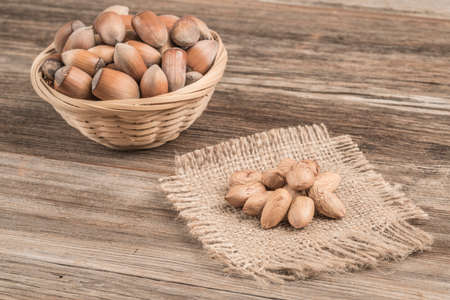 raw hazelnuts in a basket on a wooden table