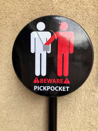 beware of pickpocketing sign on wallの写真素材