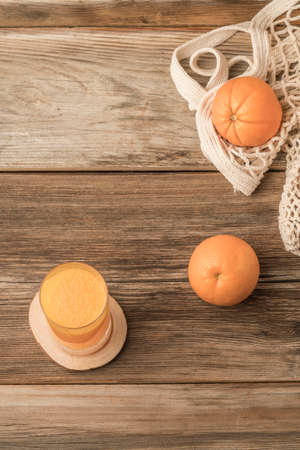 A glass of freshly squeezed orange juice on a wooden tableの写真素材