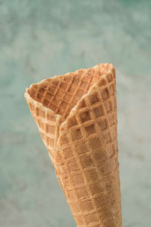 closeup of an empty ice cream cone over green background with copy spaceの写真素材